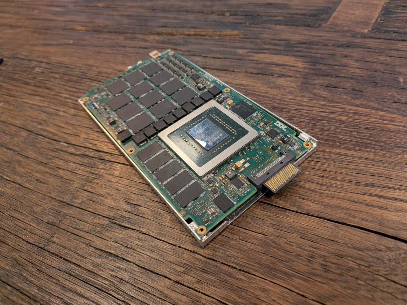 Een grafische computerkaart met blootliggende circuits en chips rust op een houten oppervlak.